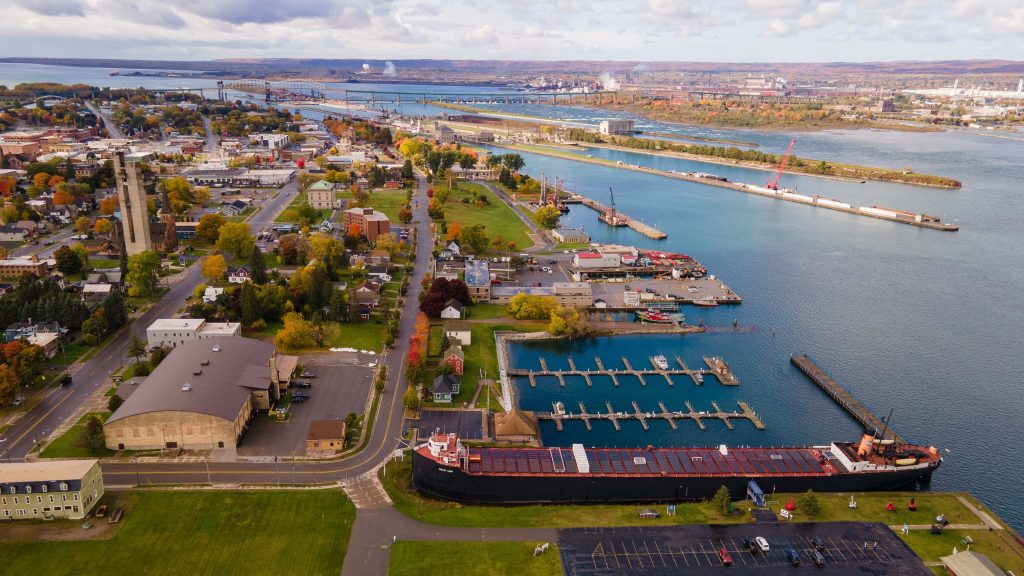 This aerial photo showcases the Soo Locks in Sault Ste Marie, Michigan, on a partly cloudy autumn day, providing a unique perspective of the lock systems and surrounding fall foliage, October 16, 2022